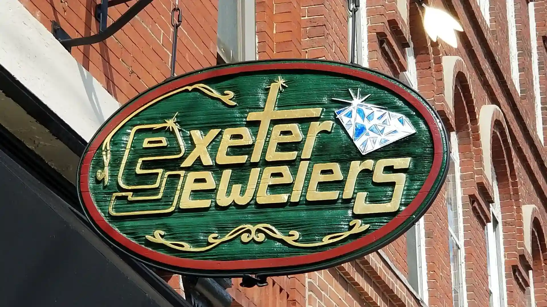Carved Exeter Jewelers sign with raised gold lettering